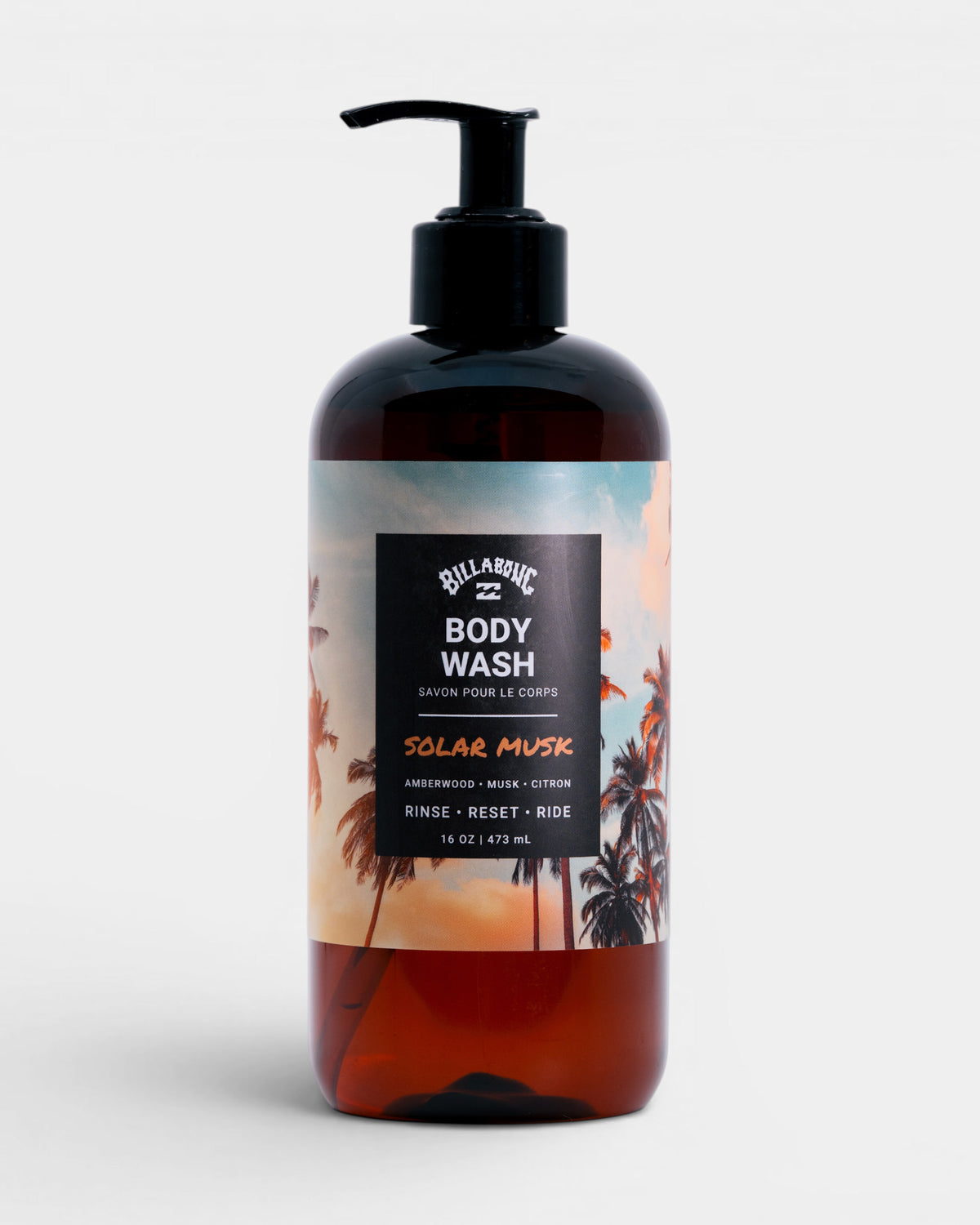 Dark amber bottle with black pump dispenser labeled "Billabong Body Wash Solar Musk" featuring palm tree sunset imagery, 16 o