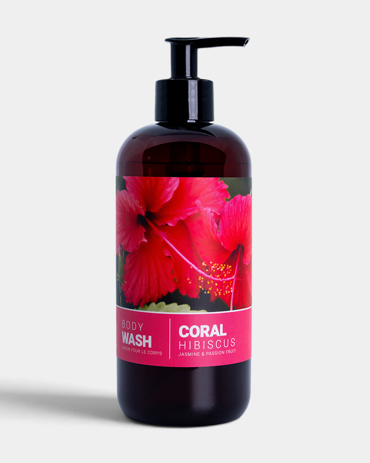 A dark amber bottle of Coral Hibiscus body wash with a black pump dispenser, featuring a label with red hibiscus flowers on a light gray background.