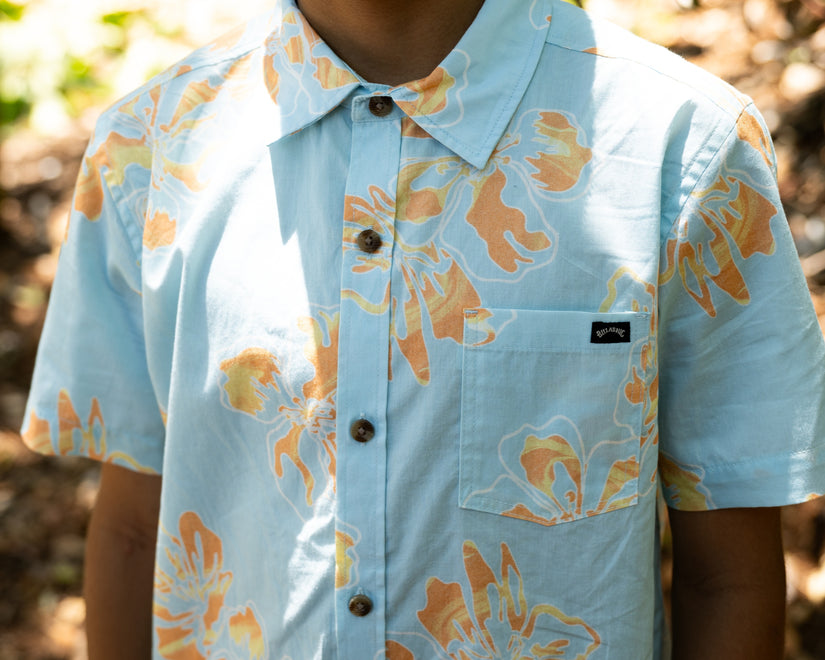 Light blue shirt with orange floral pattern worn by a person outdoors