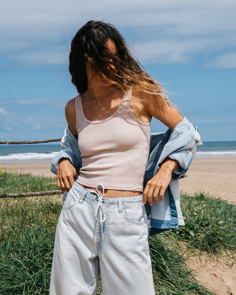 Light blue relaxed-fit pants with drawstring waist worn on model at beach.