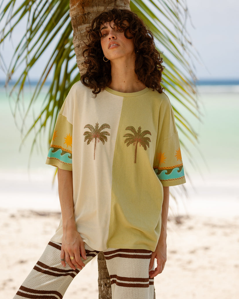 White and yellow colorblock t-shirt with palm tree and landscape graphics on chest and sleeves.