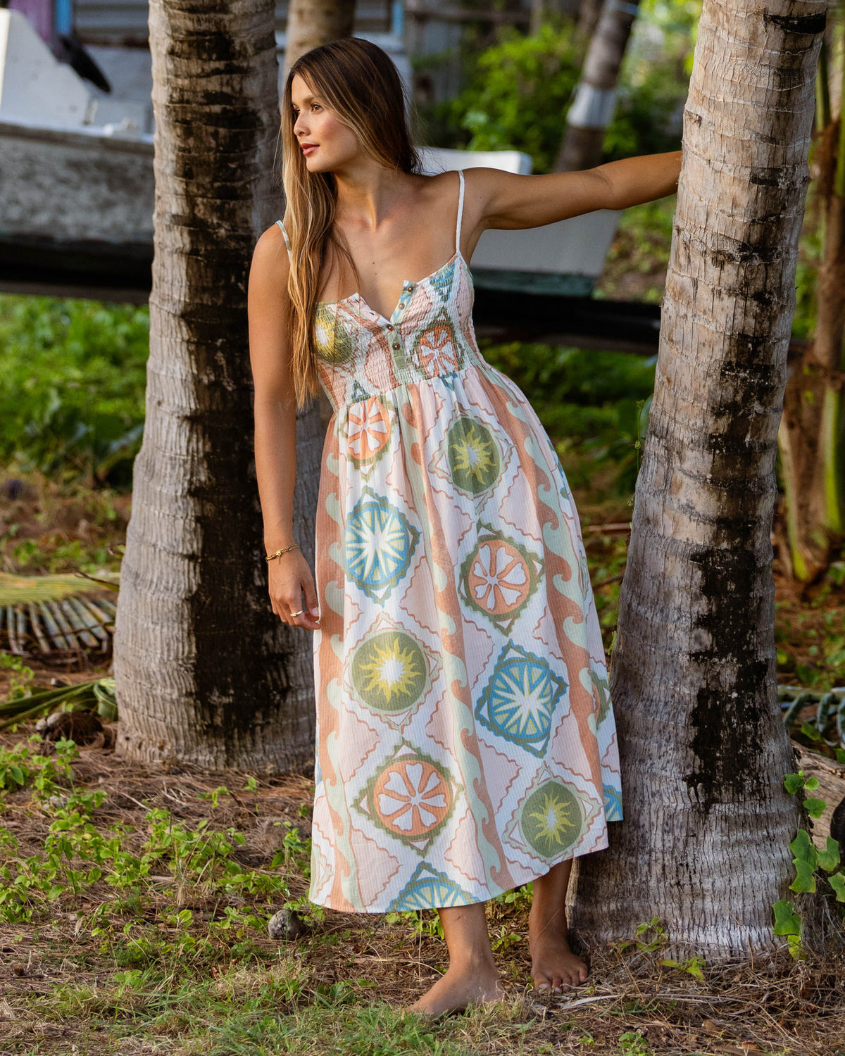 White midi dress with colorful geometric medallion print, spaghetti straps, and V-neckline.