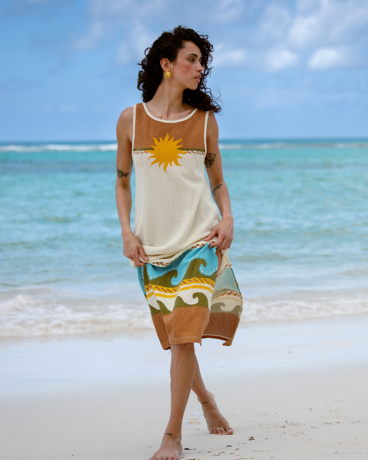 Sleeveless midi dress in caramel and cream with yellow sun graphic and blue wave pattern on skirt.