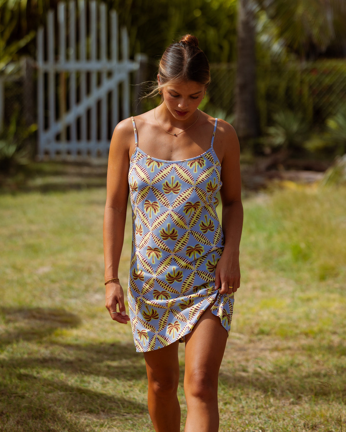 Blue slip dress with palm tree and geometric print, adjustable straps, asymmetrical hem.