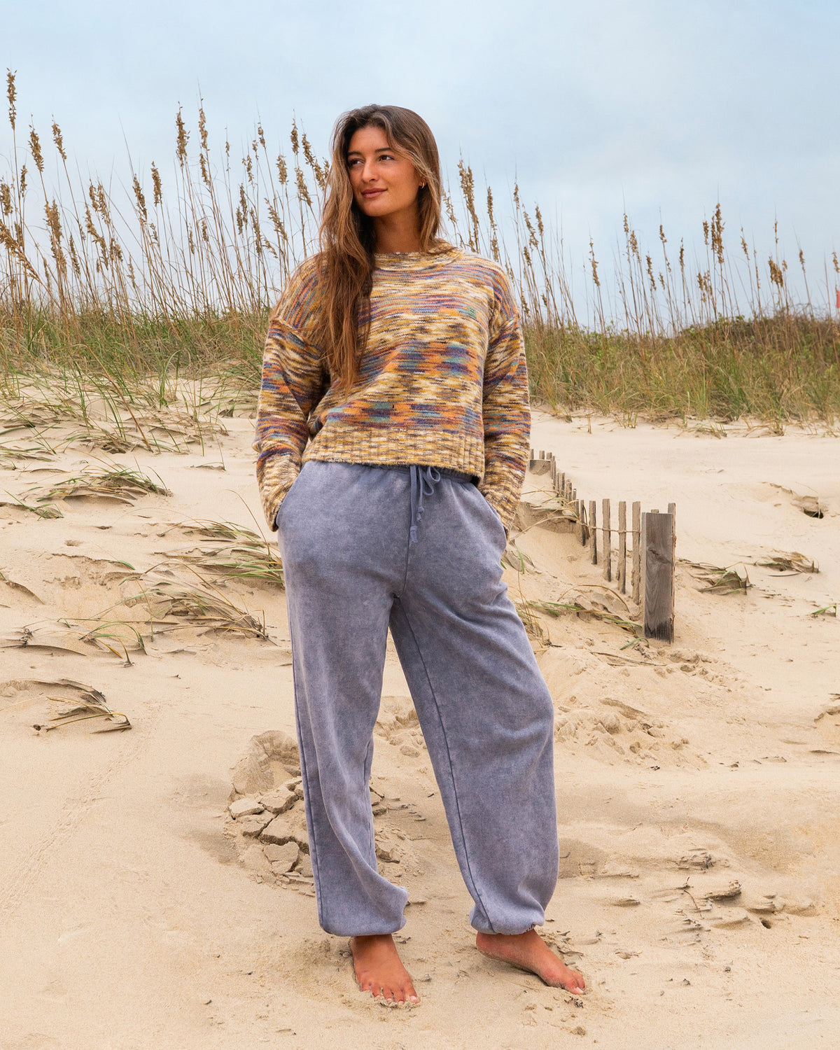 Stone blue joggers with drawstring waist and relaxed fit, shown on model at beach.