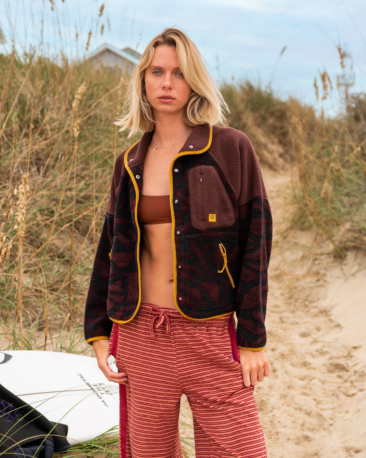 Teak sherpa fleece jacket with snap closures, yellow trim, and chest pocket on model outdoors.