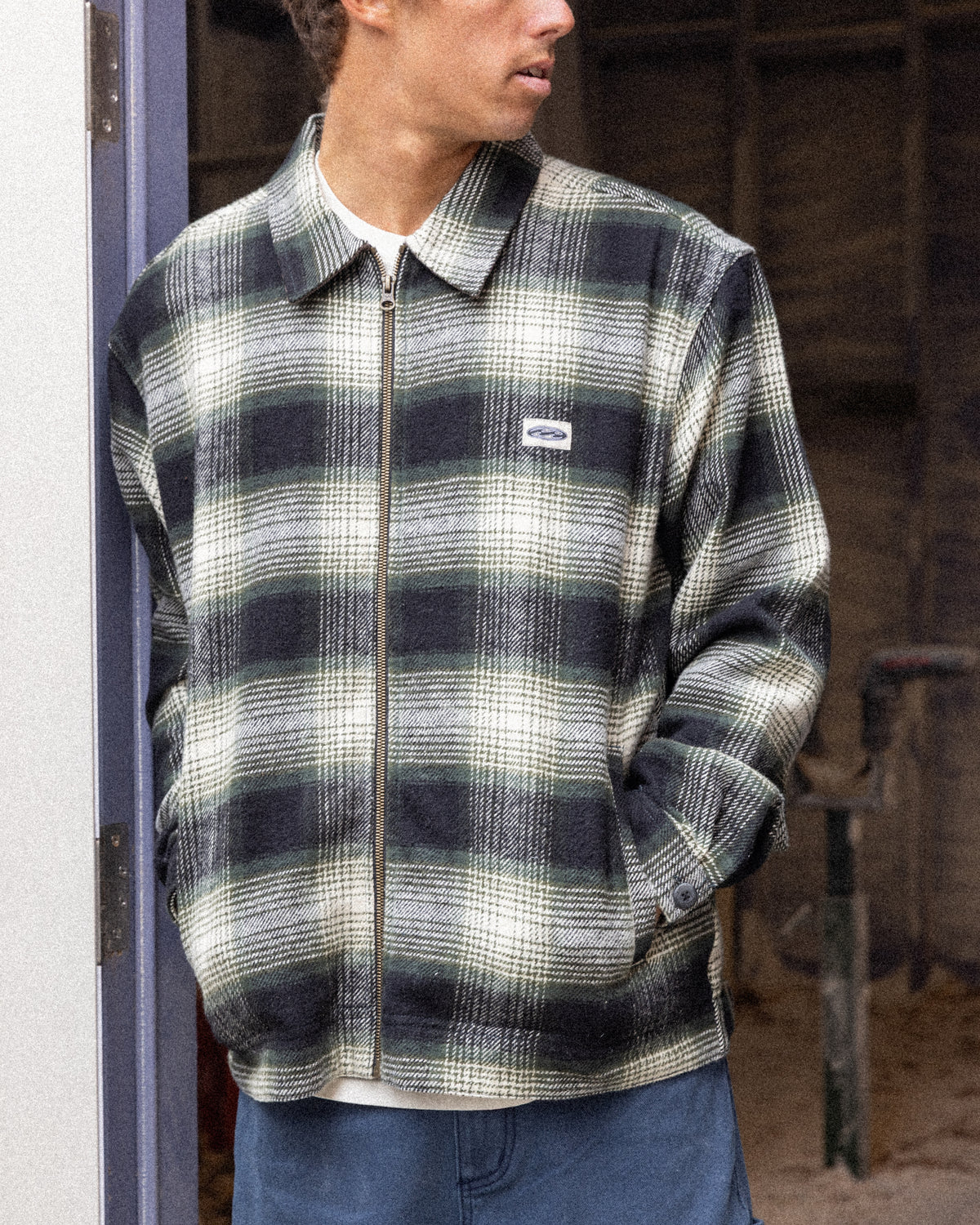 Black and white plaid jacket with collar and full-length zip, worn over white shirt.