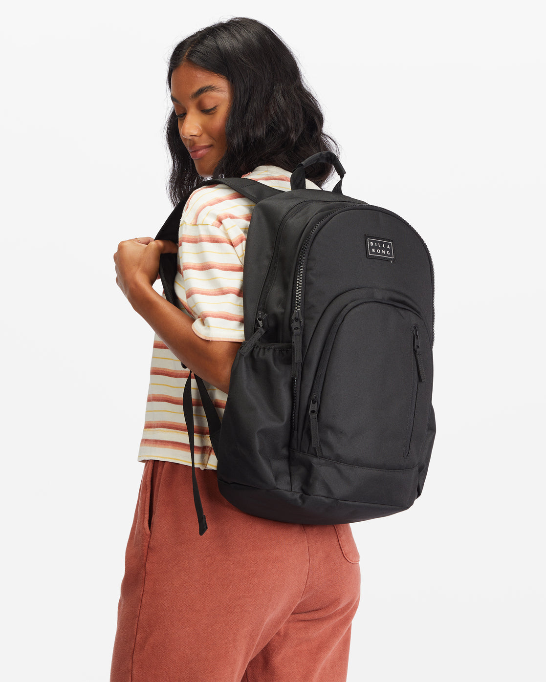 Black backpack with front zippered pocket and padded shoulder straps worn by model.